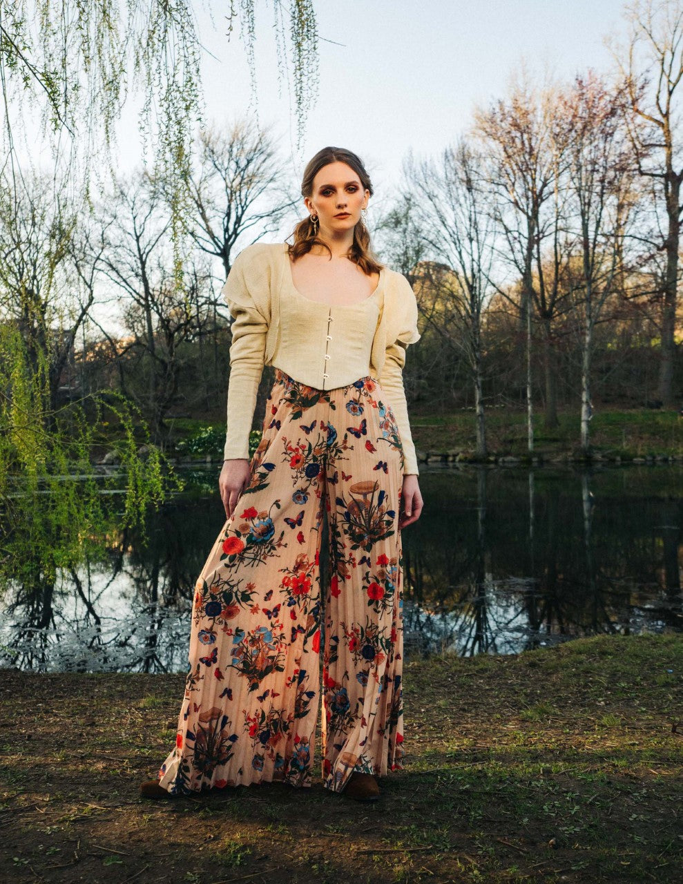 Woman in a corset jacket over a floral skirt