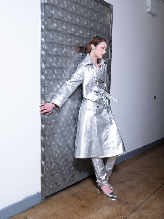 Woman wearing a long water-resistant trench coat in silver coated cotton twill with a back shield for added detail