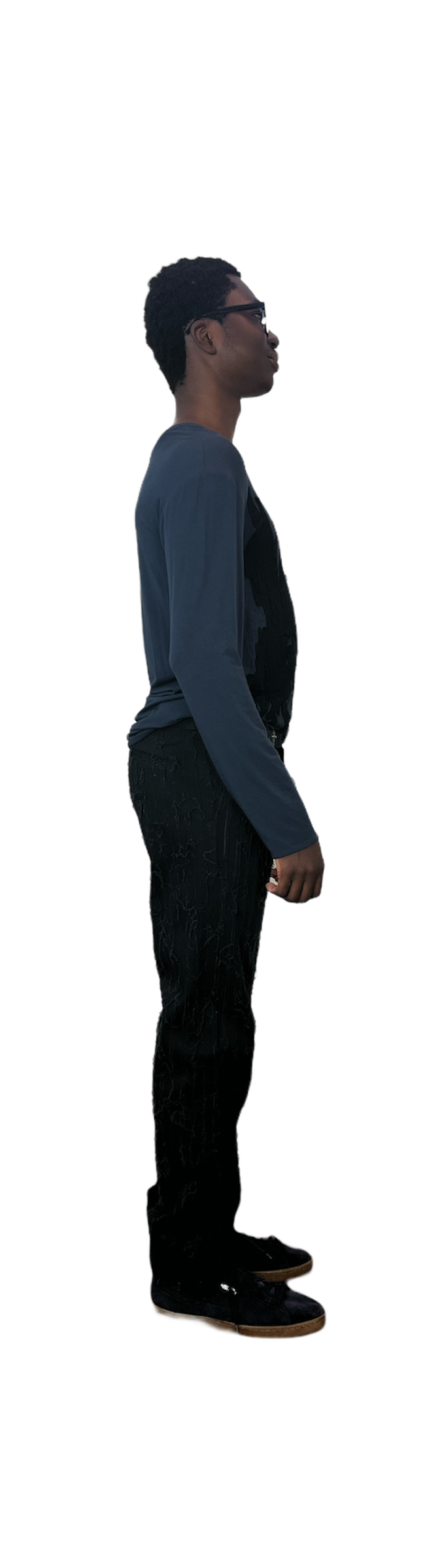 Side of man wearing a blue sweater with black shredded cotton pants with side buckle belt detail