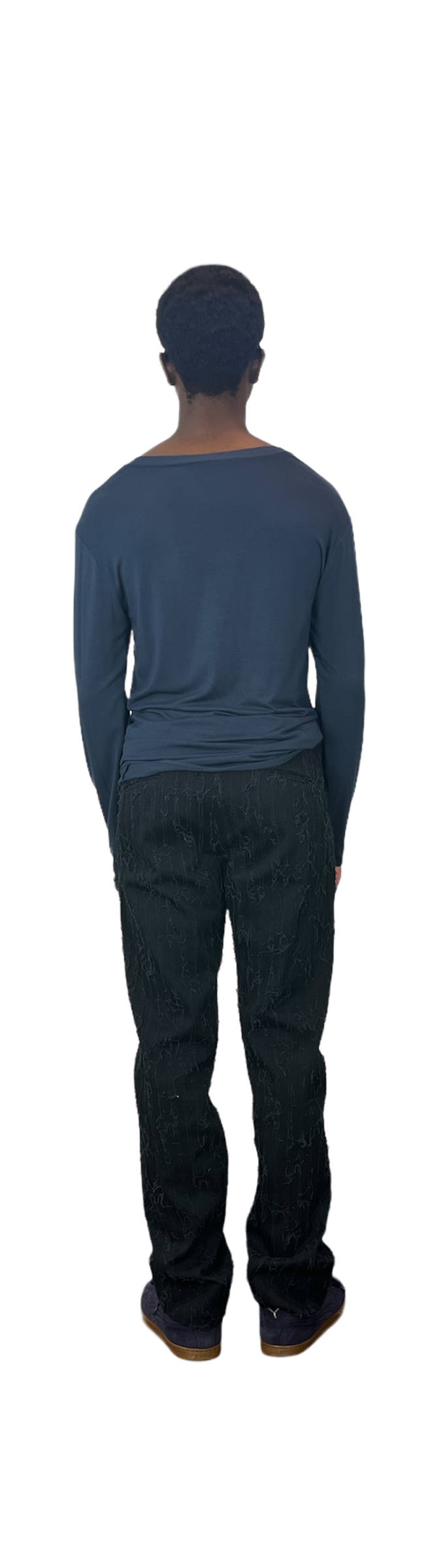 Back of man wearing a blue sweater with black shredded cotton pants with side buckle belt detail