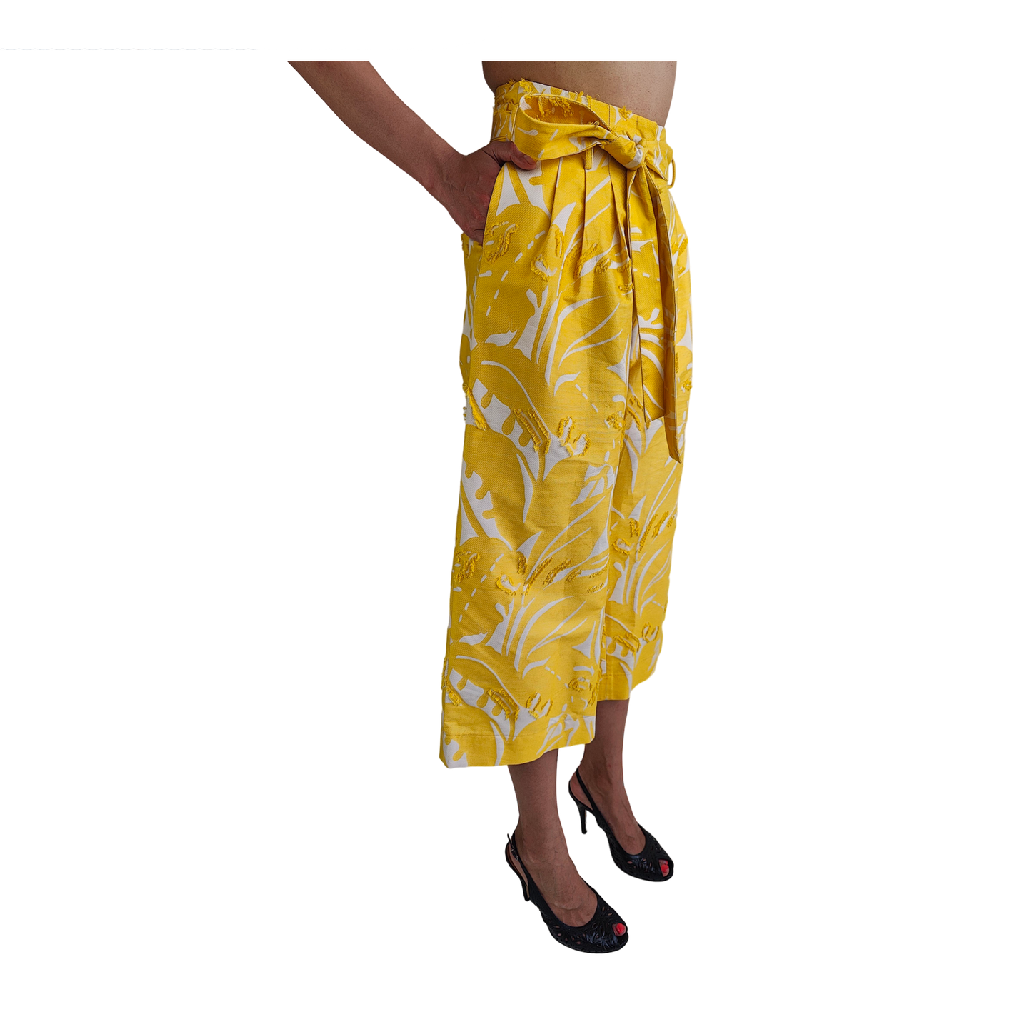 Woman wearing reversible yellow cropped wide leg gaucho style pant with white patterns