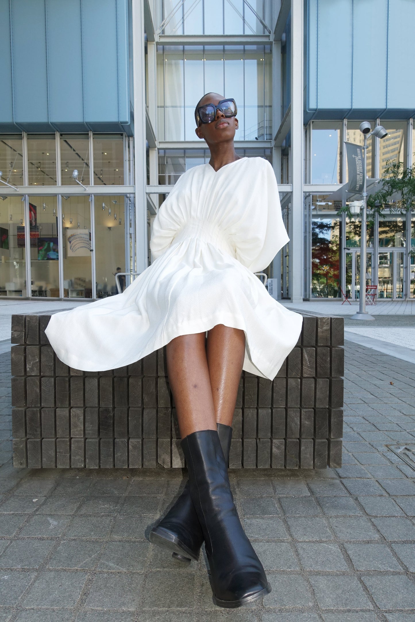 Woman wearing an ivory loose fitted v neck dress with an integrated corset