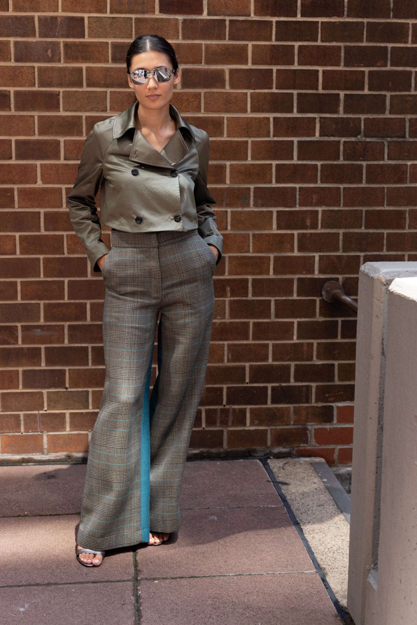 Woman wearing wool blend two tone high waisted flared pants, with double breasted jacket and sunglasses