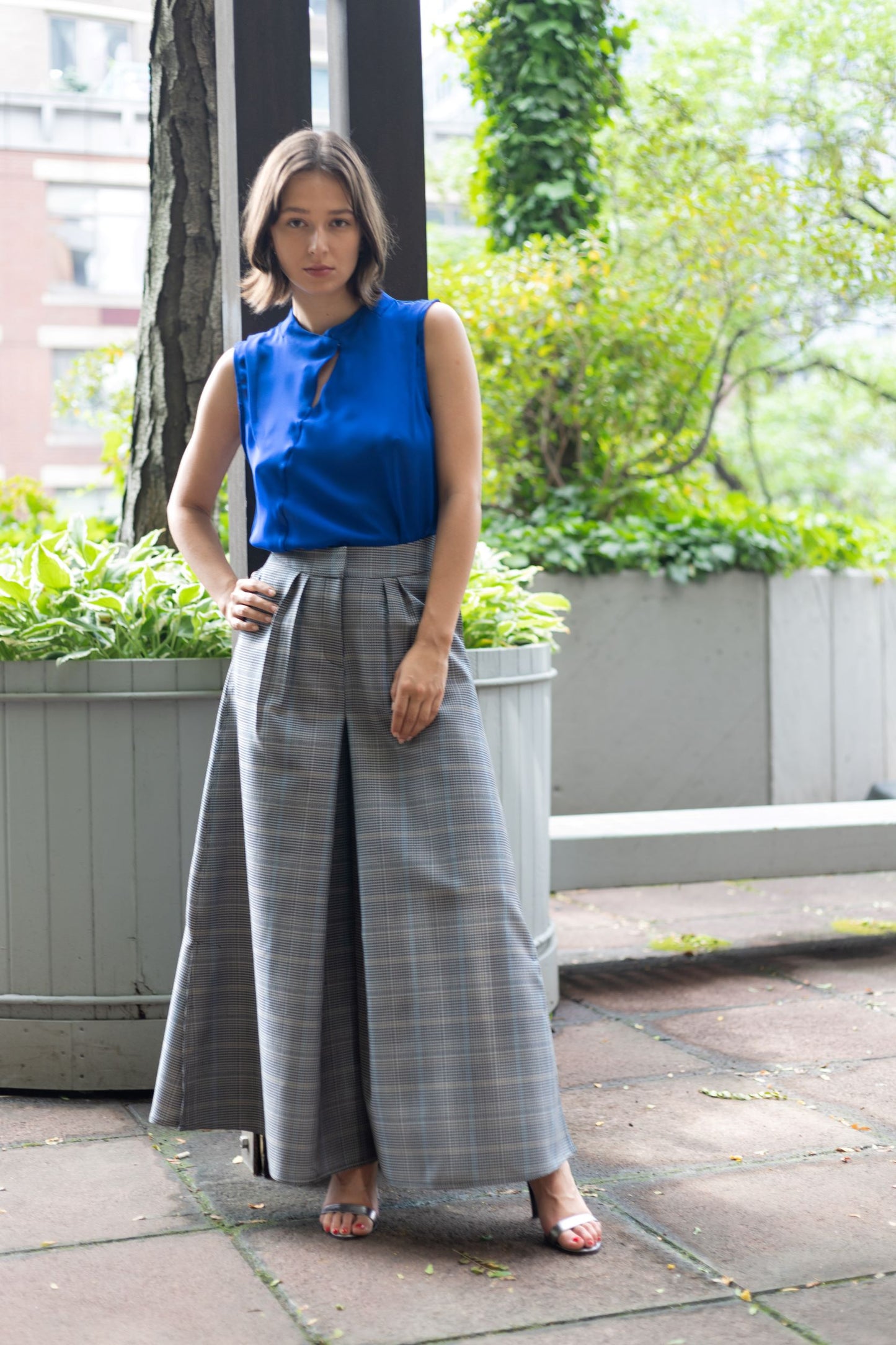 Woman wearing a gray plaid flared pants with a cobalt blue kimono top