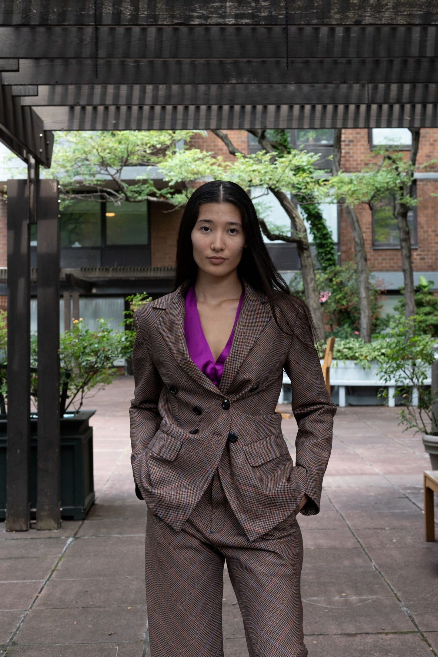 Woman wearing wool brown plaid bias-cut double breasted blazer with brown plaid pants