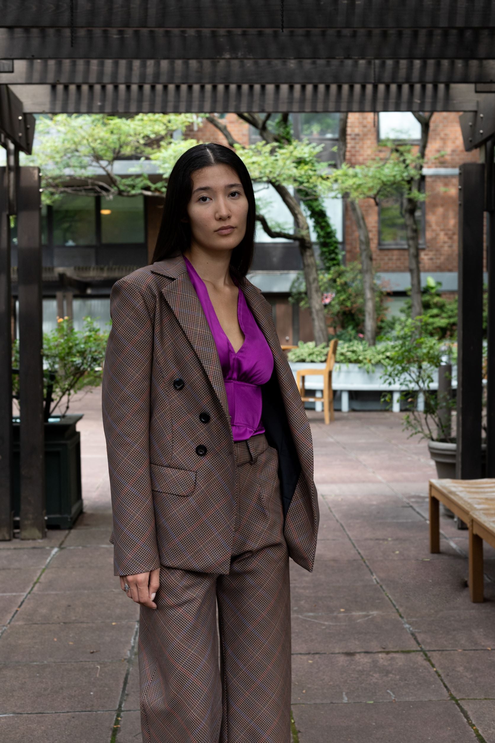 Women wearing wool brown plaid bias-cut double breasted blazer with brown plaid pants and purple shirt