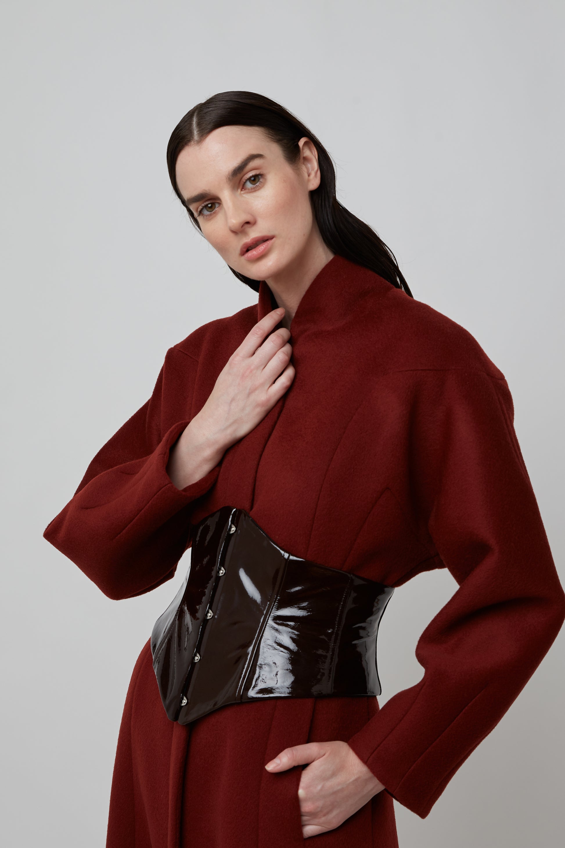 Woman wearing Structured fit-and-flare wool coat with funnel neck in Cinnamon Bark under a black leather corset